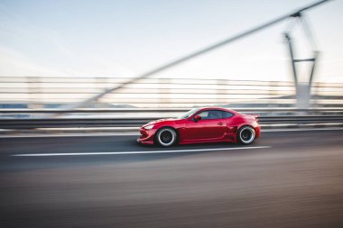 Çevre yolunda giden kırmızı şık spor araba.