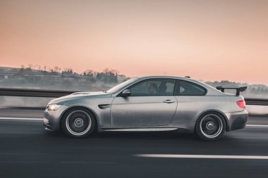 Gri modern sedan test sürüşü otoyolda, profil görüntüsü