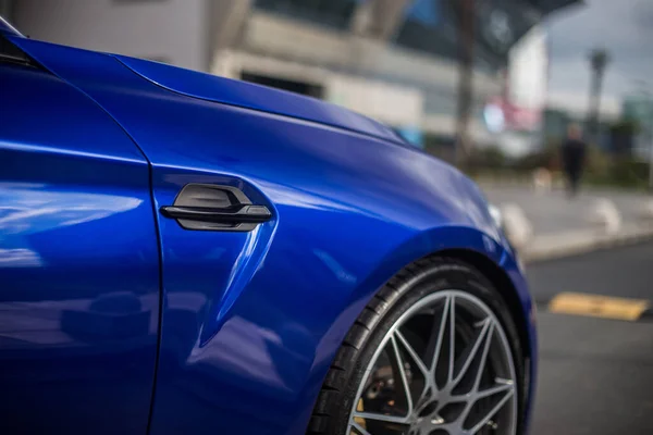 Roda preta dianteira de um carro esporte azul — Fotografia de Stock