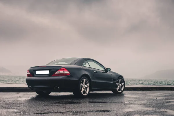 Czarny stary model sedan na plaży we mgle — Zdjęcie stockowe