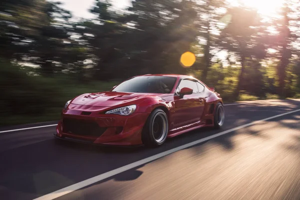 太陽光の下で森の道路でのスーパーパワーの赤い車のレース — ストック写真