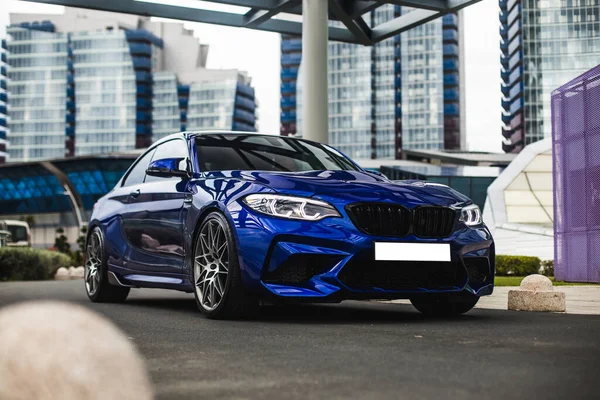 Ofislerin karşısındaki iş alanında mavi sedan.