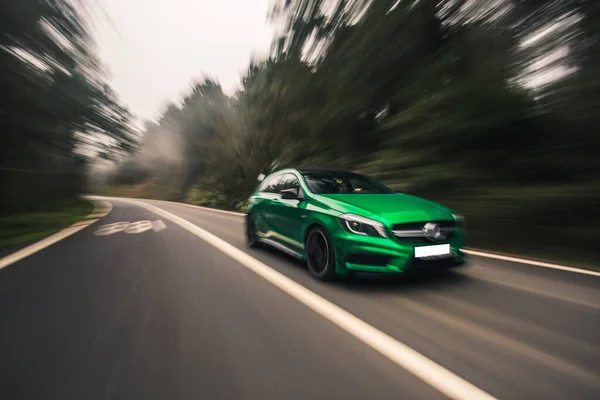 Green mini sport mașină de conducere pe autostradă într-o vreme ploioasă ceață, vedere încețoșată — Fotografie, imagine de stoc