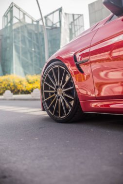 İş bölgesinde kırmızı model sedan, ön teker manzaralı.
