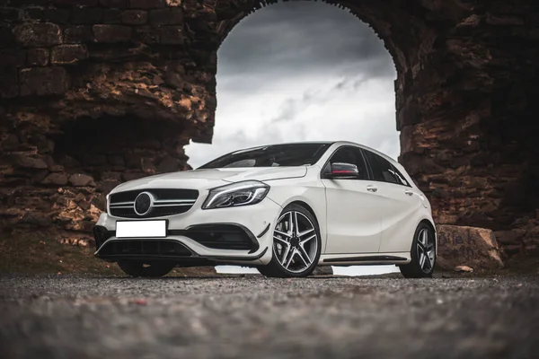 Witte sportwagen geparkeerd onder de grote poort — Stockfoto