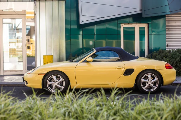 Um carro esporte amarelo na rua estacionamento ao ar livre — Fotografia de Stock