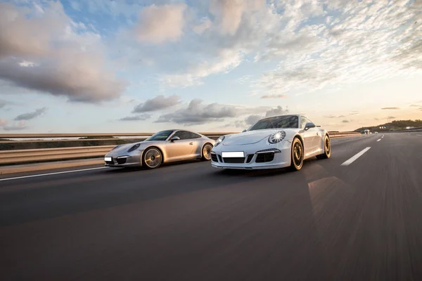 Movimento di velocità tra due auto sportive in un tempo nuvoloso — Foto Stock