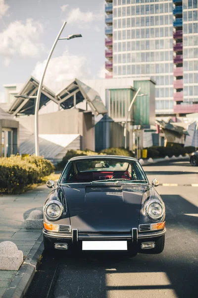 Vintage coche retro en el aparcamiento al aire libre en frente de una sala de exposición — Foto de Stock