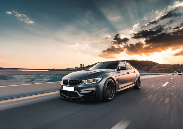 Şehir merkezinde hız sürüşü, deniz kenarında siyah bir sedan.