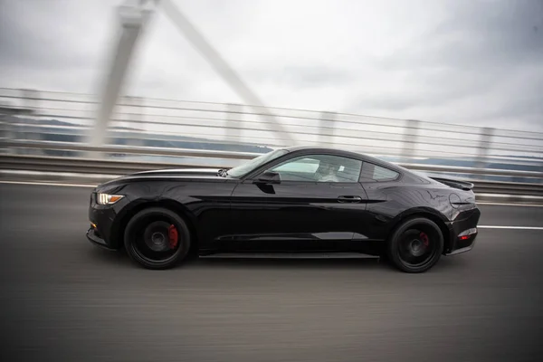 Mengendarai mobil hitam di jalan bebas hambatan di atas jembatan, pandangan kecepatan kabur — Stok Foto