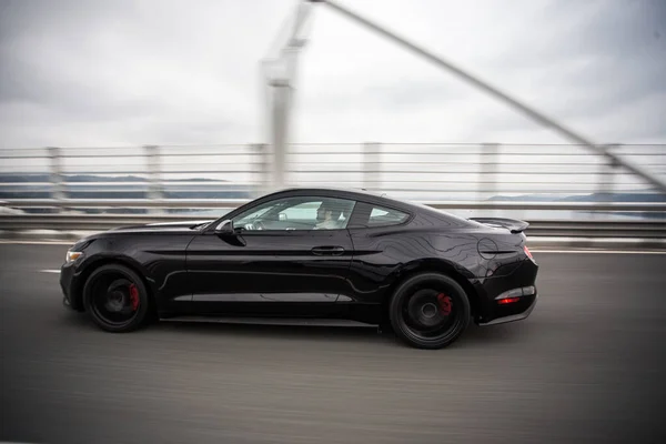 橋の上の高速道路で黒い車を運転、プロフィールビュー — ストック写真