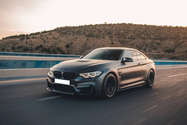 Yeni model siyah sedan dağları aşan otoyolda.