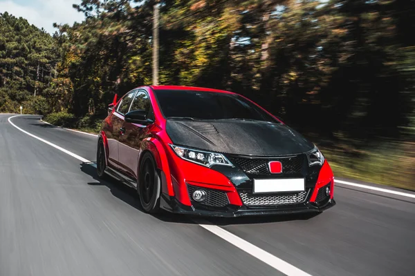 Supercar moderne noire avec toit bordeaux dans la forêt, mouvement rapide — Photo