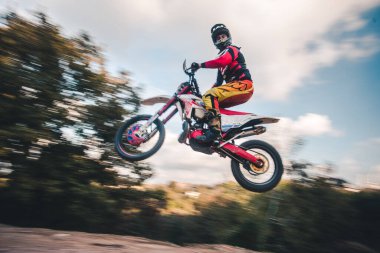 Kasklı motosikletle atlayan bir sürücü.