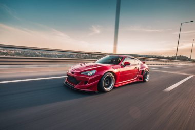 Büyük otoyolda kırmızı yarış arabası, panoramik manzaralı, açı manzaralı.