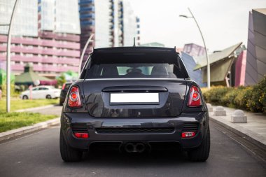 Açık hava otoparkında siyah bir cip var. 