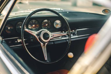 Bir retro arabanın kontrol tekerleği ve hız göstergesi sistemi, pencereden görünüm