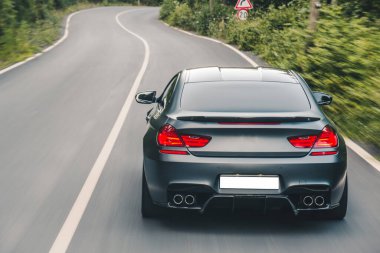 Gri, evrensel sedan ve kırmızı ışıklar ormanda seyahat ediyor.