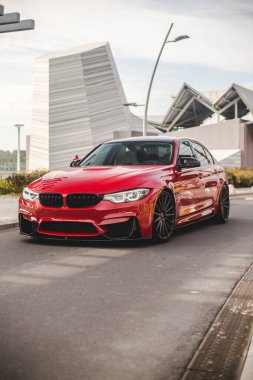 Boş şehir yollarında kırmızı model sedan, ön manzara.