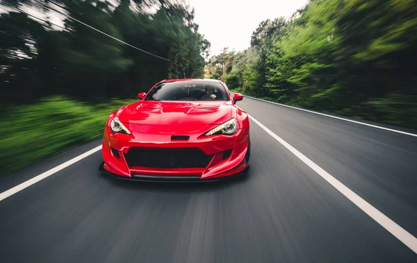 Superpower red racing car on the landscape drive, blurred view — Stock Photo, Image