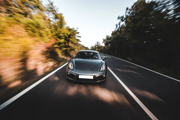 Černá sportovní auto rychlost disk na dálnici přes les — Stock fotografie