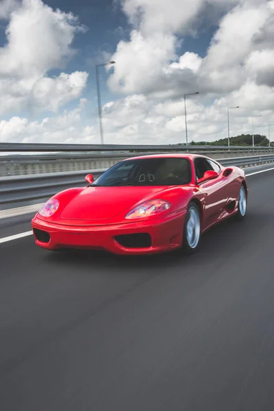 Supercar rojo de carreras en la carretera bajo el cielo azul — Foto de Stock