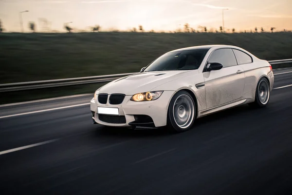 Bianco moderno berlina test drive in autostrada la sera — Foto Stock