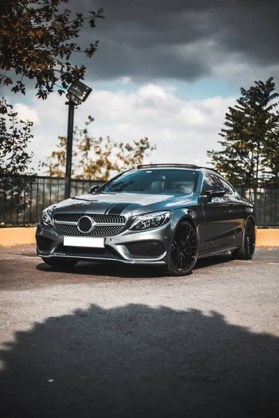 Kırsal alanda park etmiş mavi spor araba, ön manzara.