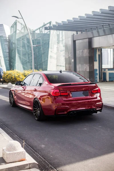 Rood model sedan op de lege straten van de stad, in de zakenwijk, van achteren bekeken — Stockfoto