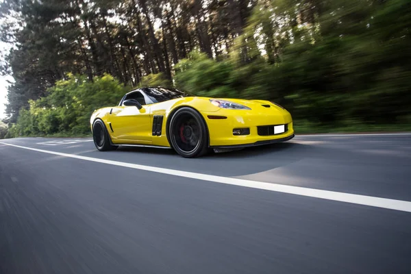 Yellow supercar speed motion through forest — Stock Photo, Image