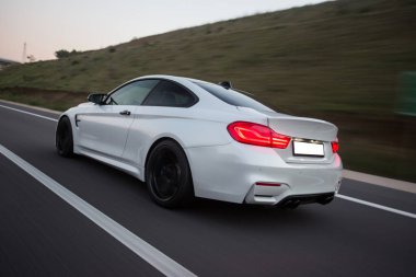 Alacakaranlıkta dağ yollarında beyaz sedan.