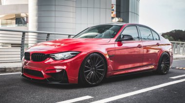 Modern bir konutun önünde, boş bir yolda kırmızı evrensel bir cip.