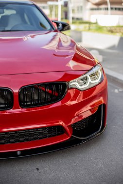 Kırmızı model sedan, kuru asfalt üzerinde, tarihi park yerinde.