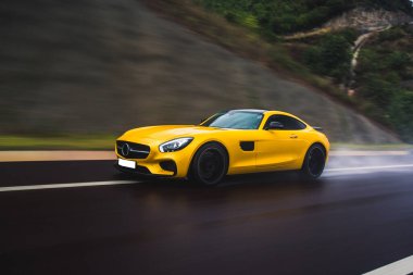 Sarı renkli modern teknoloji spor model araba yağmurlu bir havada otoyolda