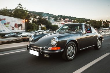 Alacakaranlıkta şehirde eski moda siyah araba