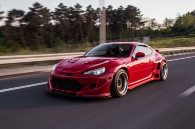 Alacakaranlıkta panoramik manzaralı kırmızı yarış arabası.