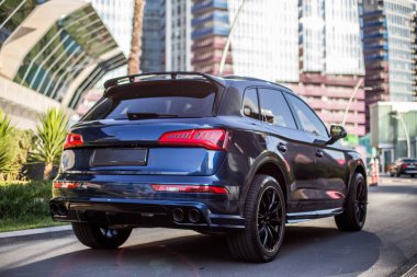 Park yerinde kırmızı ksenon ışıkları olan mavi minibüs.