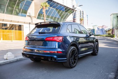 Bir binanın önündeki turistik bir şehirde mavi spor off-road aracı