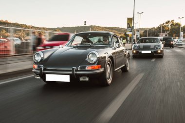 Siyah klasik araba gün batımında yolda, ön manzara