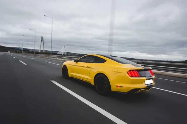 Жовтий спортивний автомобіль на гоночній трасі через ландшафти — стокове фото