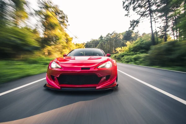 Superpotência carro de corrida vermelho na unidade de paisagem, vista frontal — Fotografia de Stock