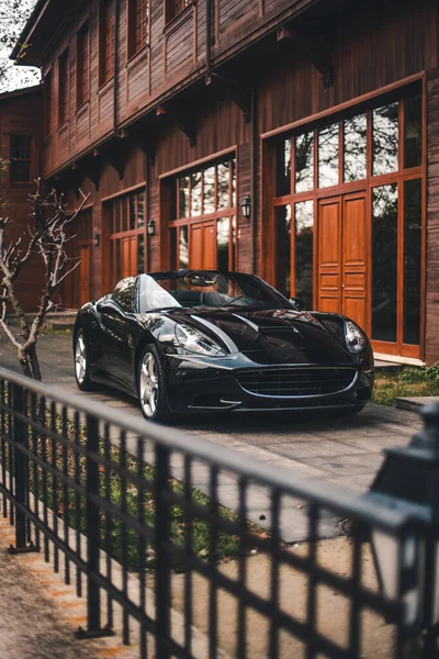 Carro preto no estacionamento ao ar livre em frente a uma propriedade no outono — Fotografia de Stock