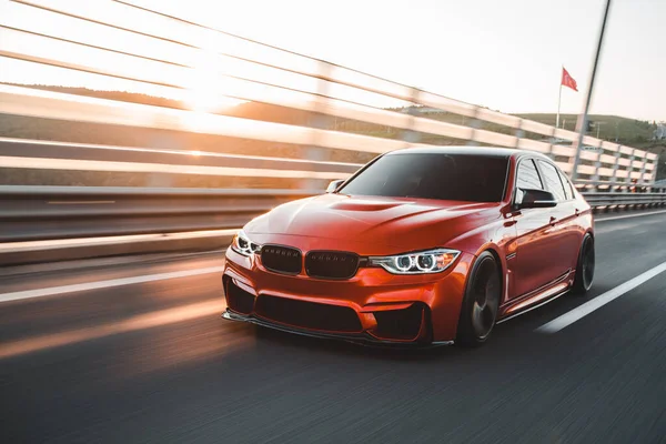 Red family sedan on the modern bridge — Stock Photo, Image