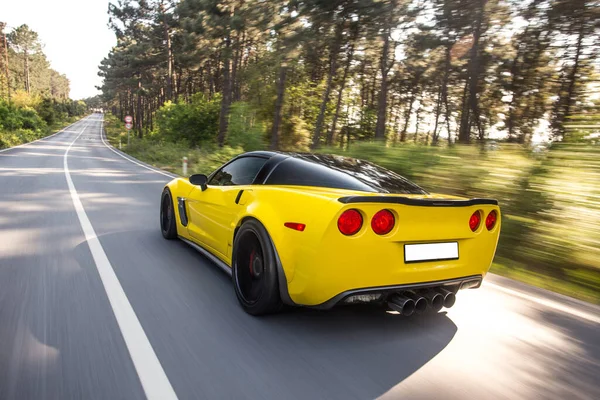 Carro esporte de luxo amarelo test drive na estrada da floresta — Fotografia de Stock