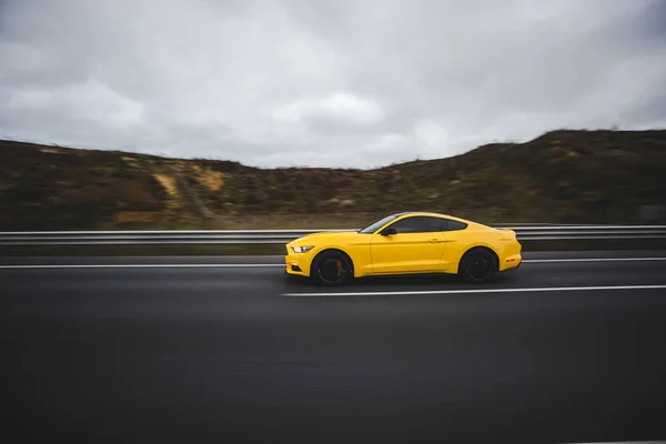 Κίτρινο σπορ αυτοκίνητο στην πίστα αγώνων πάνω από τα τοπία στα υψίπεδα — Φωτογραφία Αρχείου