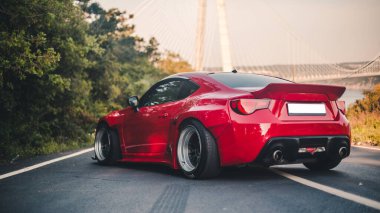 Tepedeki modern kırmızı yarış arabası reklamı.