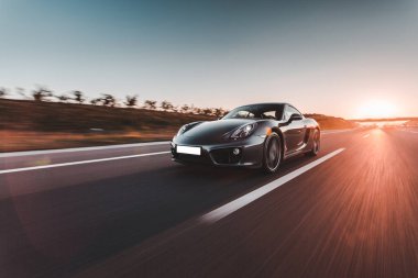 Gün batımında otobanda lacivert spor araba sürüşü