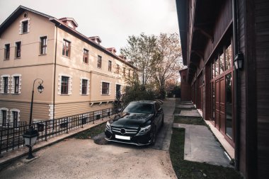 Ortaçağ kasabasının tarihi binasının bahçesinde siyah bir sedan araba.