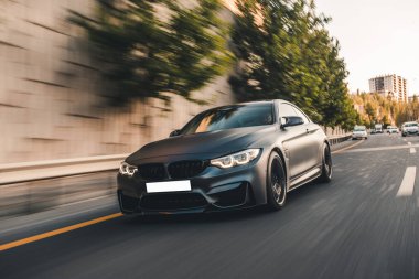 Yeni model siyah sedan şehir merkezindeki otoyolda.