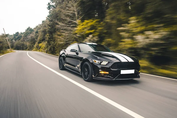 Zwarte sport sedan met witte autotuning op het platteland, bewolkt weer — Stockfoto